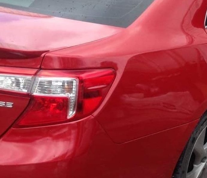 The same red sedan after repair, with a new bumper and matched paint
