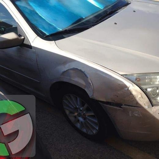 Tan sedan with front fender and bumper damage