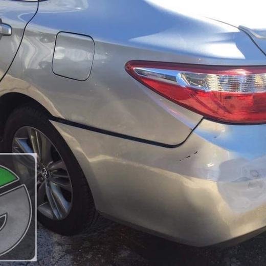 Silver sedan with rear quarter panel damage before repair